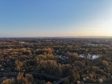 Bu hava manzarası canlı sonbahar yapraklarıyla çevrili dolambaçlı bir nehri gözler önüne seriyor, doğal renkleri vurguluyor Maschsee Hannover