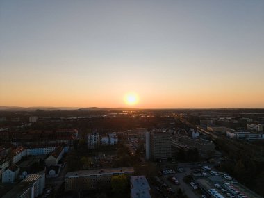 Ufuk çizgisini aydınlatan ve manzarayı çevreleyen nefes kesici bir günbatımı, şehir manzarası görselleri için mükemmel..