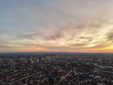 Gün batımında nefes kesici ve büyüleyici bir şehir manzarası. Gökyüzündeki canlı şehir yaşamını ve renkli renkleri gözler önüne seriyor. Hannover Listesi Düşük Saksonya