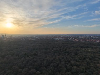 Nefes kesici bir hava manzarası, verimli yeşil ormanı ve canlı şehir manzarasını gün batımında Hannover Listesi Aşağı Saksonya 'da yakalar.