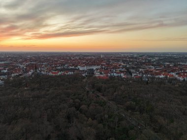 Göz kamaştırıcı hava manzarası yemyeşil Hannover Aşağı Saksonya 'nın içinde yuva yapmış canlı bir şehrin üzerinde güzel bir gün batımı yakalıyor.
