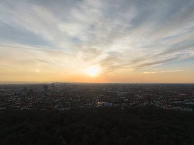Nefes kesici ve büyüleyici bir gün batımı manzarası çarpıcı gökyüzü ve Hannover Listesi Düşük Saksonya ile canlı bir şehir siluetini aydınlatıyor.