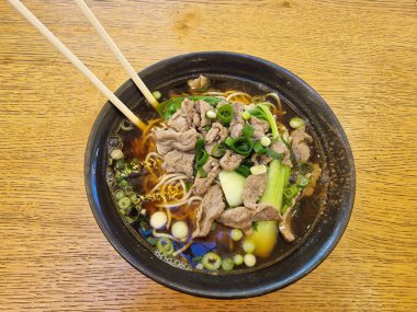 Üzerine leziz et ve taze sebzeler konmuş bir kase şehriye çorbası. Rahatlatıcı bir yemek için mükemmel..