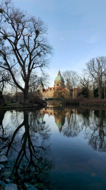 Huzurlu bir manzara, sakin sulardaki tarihi bir yapının çarpıcı yansımasını sergiliyor. Maschsee Hannover