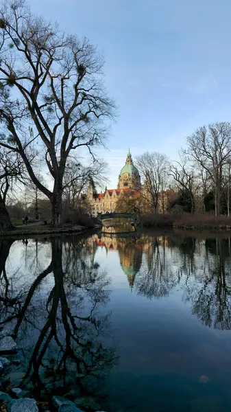 Huzurlu bir manzara, sakin sulardaki tarihi bir yapının çarpıcı yansımasını sergiliyor. Maschsee Hannover