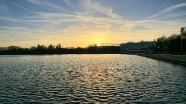 Huzurlu gölü aydınlatan nefes kesen bir gün batımı, güzel yansımalar yaratırken aynı zamanda Maschsee Hannover 'ı gözler önüne seriyor.