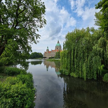 Yeşillik ve sakin gölle çevrili büyük bir şatonun gerçekten resimsel manzarasına bakın.