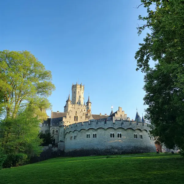 Parlak ağaçlar ve açık mavi bir gökyüzü tarafından güzel çerçevelenmiş büyüleyici bir resim şatosu, doğa aşıkları Schloss Marienburg için ideal.
