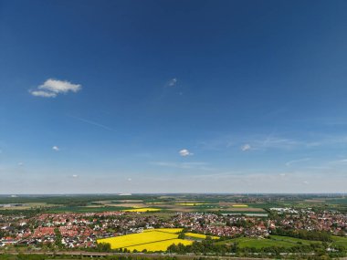 Geniş ve güzel bir manzara, berrak mavi gökyüzü Koldinger 'in altında huzurlu bir köyün yanında canlı sarı tarlalar sergiliyor. Hannover Pattensen' i