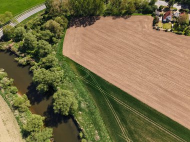 Bu çarpıcı hava manzarası geniş tarlaları ve yemyeşil yeşil Koldinger ile çevrili dolambaçlı bir nehri güzel bir şekilde sergiliyor.