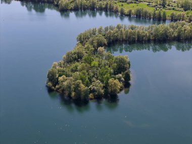 Bir hava manzarası, sakin mavi sulardaki yemyeşil bir adayı yakalar, doğal güzellikleri, dinginliği ve güzelliği gözler önüne serer.