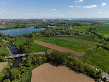 Göz kamaştırıcı bir hava görüntüsü canlı yeşil alanlar, dingin bir göl ve sarmal bir nehir olan Koldinger Pattensen 'i gösteriyor.