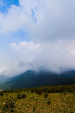 Bulutları ve mavi gökyüzü olan güzel bir manzara.