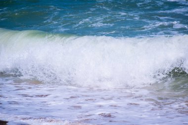 Dalgalar deniz ve Kum Plajı üzerinde köpük