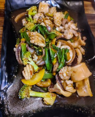 Brokoli ve mantarlı bir tabak kızarmış kalamar.