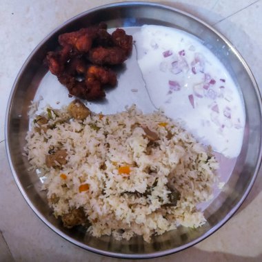 Briyani, tavuk pokada ve tabakta salata.