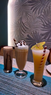 Masada bir fincan kahve ve mojito ile nefis bir çikolatalı milkshake 'in yakın çekimi.