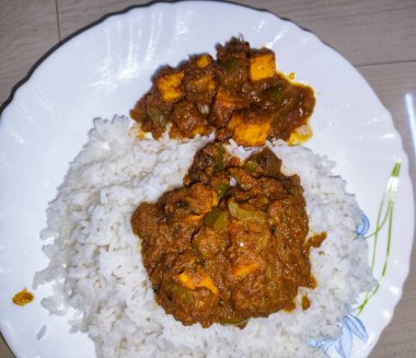 Bir tabak körili tavuk, pilav ve sebze.