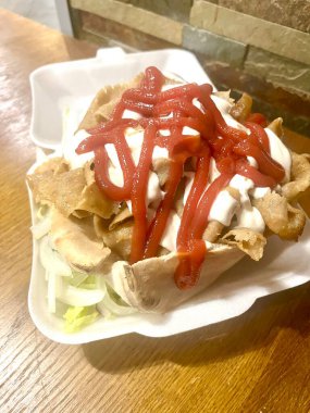 Doner kebab takeaway served in pita bread with salad, tomato sauce and mayonaise 