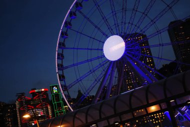 Hong Kong, Çin - 4 Eylül 2015: gece dönme dolap. Arka planda HSBC banka binası ve diğer gökdelenler.