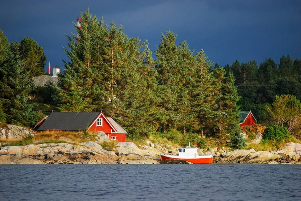 바위가 해안에 있었습니다 전통적으로 나무집들이 위에는 노르웨이인 피오르의 모습이 보인다 — 스톡 사진