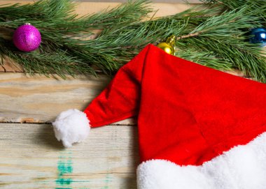 Köknar dallı eski tahtalarda Noel Baba şapkası.