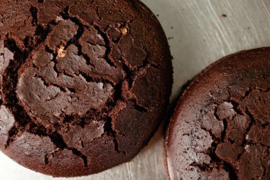 Çürümüş çikolatalı kekler metal bir yüzeyde soğuyor, zengin dokuları ortaya çıkarıyor ve her tür kutlama ya da toplama için mükemmel bir aroma yaratıyor.