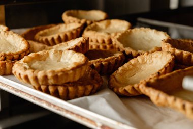 Sabahın erken saatlerinde sıcacık bir mutfak ortamında fırın tepsisinde taze pişmiş hamur kabukları soğuyor.
