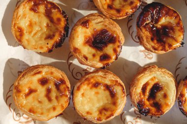 Taze pişmiş Pastel de nata veya Pastel de Belm. Portekiz 'in en ünlü tatlısı. Fırın kağıdındaki tart