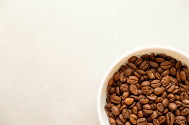 Beyaz bir kâsede taze kavrulmuş kahve çekirdeğinin zengin aromasını keşfetmek.