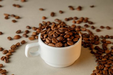 Beyaz bardaktan taşan kahve çekirdekleri sıcak bir kahve anı yaratır.