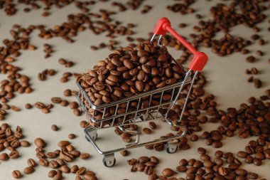 Yumuşak bir arka planda kavrulmuş kahve çekirdekleri ile dolu alışveriş arabası.