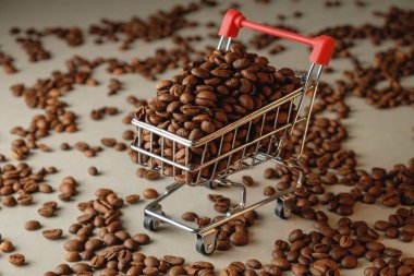 Dokulu bir yüzeyde küçük bir alışveriş arabasından kahve çekirdekleri taşar.