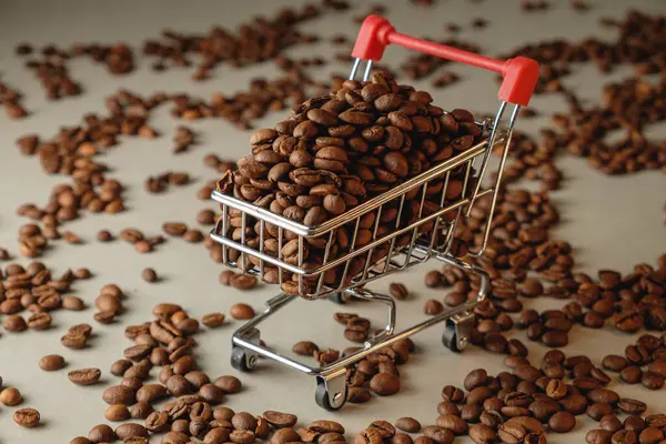 Dokulu bir yüzeyde küçük bir alışveriş arabasından kahve çekirdekleri taşar.