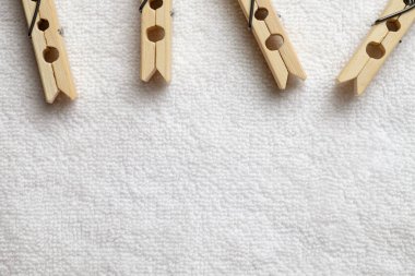 Ahşap mandallar yumuşak bir havluya tutunur, günlük sadeliği yakalar.