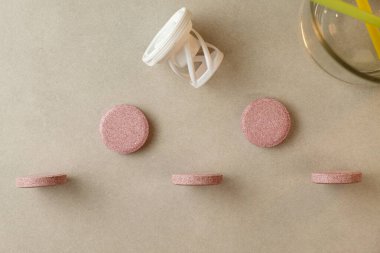 Doğal takviye tabletleri tarafsız bir yüzeye düzgün yerleştirilmiş.