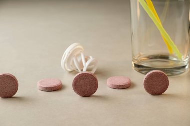 Modern bir mutfak ortamında renkli tabletler ve bir bardak tüketimi bekliyor.