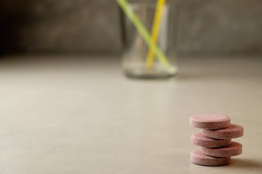 Canlı sağlık tabletleri, huzurlu bir ortamda renkli pipetlerin yanına istiflenmiş.