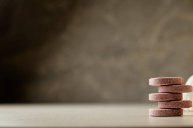 Minimalist yüzeyde dokulu zemin üzerine istiflenmiş doğal sağlık hapları