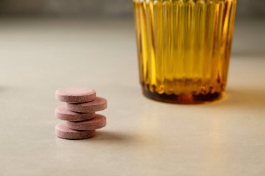 Gün batımında canlı bir camın yanına istiflenmiş renkli tabletler.