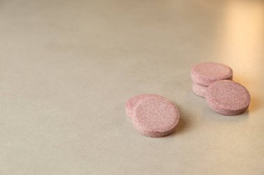 Pürüzsüz bir yüzeyde dinlenen renkli yuvarlak tabletler ışığı güzelce yakalar.