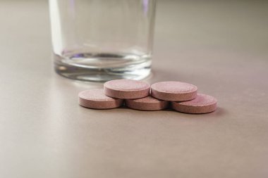 Sakinleştirici bir ortamda su ve sağlık için tabletler ve bir bardak bekliyor.