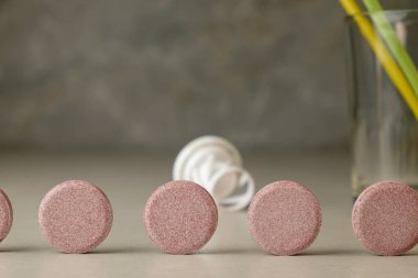 Renkli tabletler, cam ve pipetlerin yanındaki tezgahta düzgünce dizilmiş.