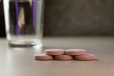 İlaçlar cam önünde düzgünce dizilmiş, tezgahın üstünde, yumuşak ışıkta.