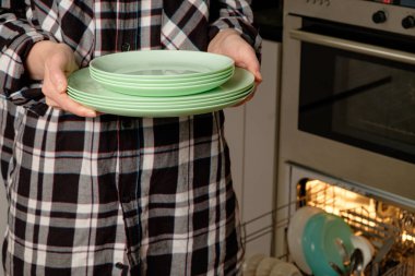 Nefis bir yemekten sonra elinde yeşil tabaklar tutan kişi.