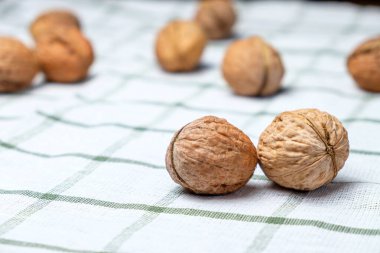 Güzel beyaz bir havluya izole edilmiş taze cevizler. Menü için arka plan. Metin için boşluk