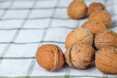 Taze cevizler beyaz bir havluda yatıyor, sabah güneşi güzel ahşap kabuğu aydınlatıyor..