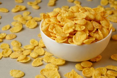 Güneşli bir sabahta altın mısır gevreğiyle dolu kahvaltı kasesi.