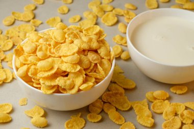 Sıcak bir mutfakta gevrek mısır gevreği ve kremalı süt.