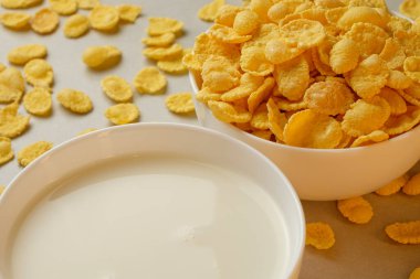 Sabah ışığında gevrek mısır gevreği ve kremalı sütle dolu kahvaltı kasesi.